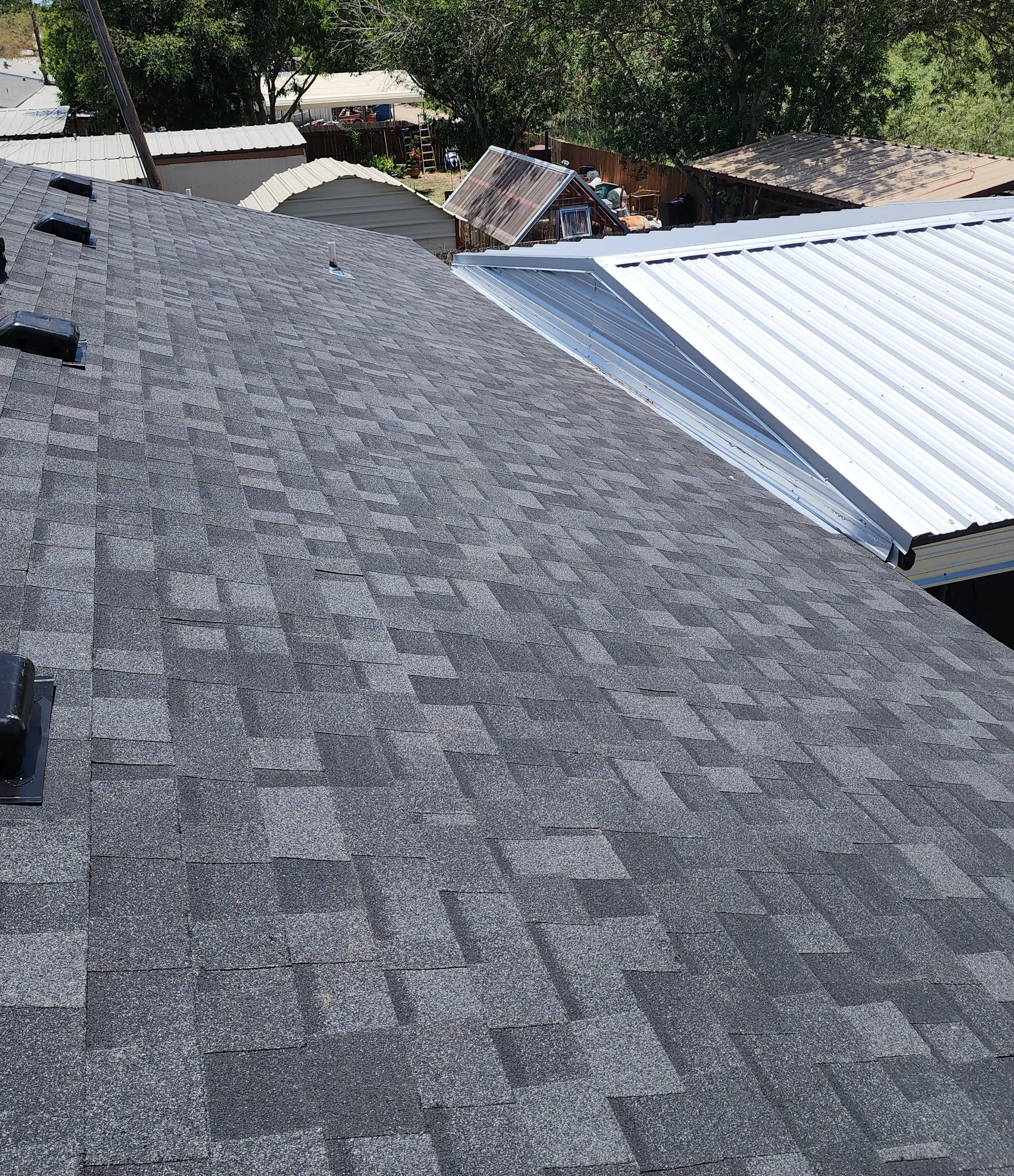 Metal roofing and flashing beside a shingle roof