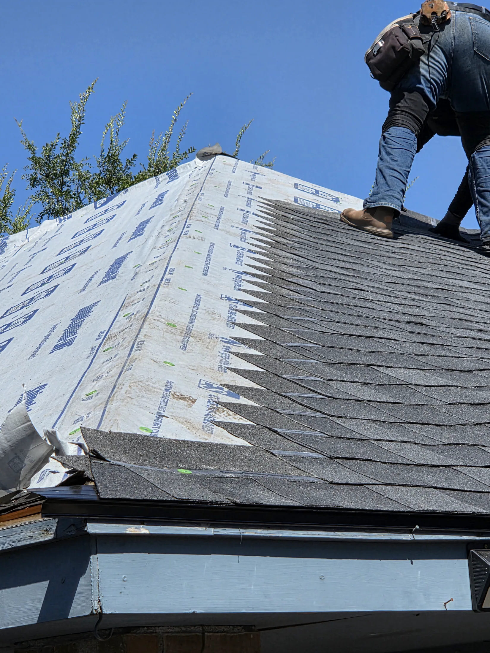 3J technician installing shingles at a roof edge